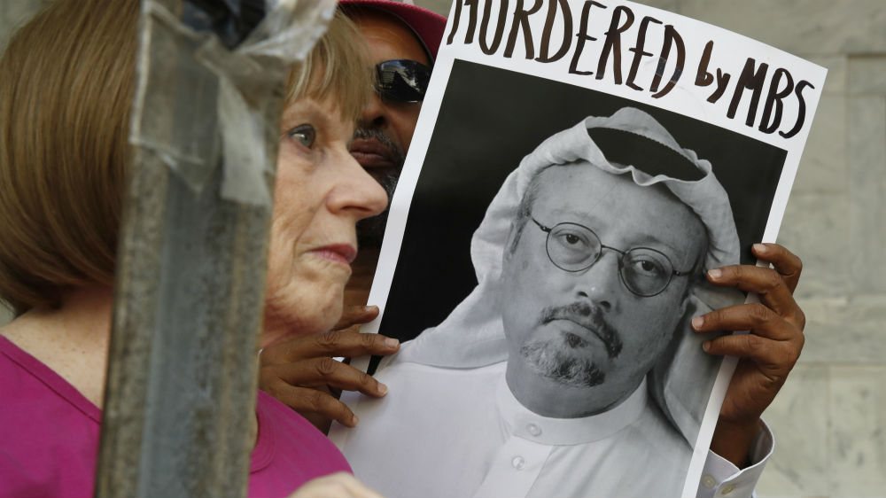 People hold signs during a protest at the Saudi embassy in Washington, DC over Khashoggi's disappearance [Jacquelyn Martin/AP]