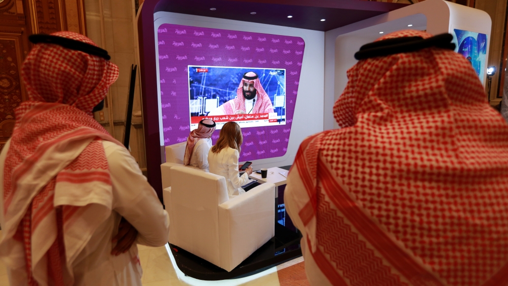 Participants watch on TV, as Saudi Crown Prince Mohammed bin Salman as he delivers a speech during the Future Investment Initiative Forum in Riyadh