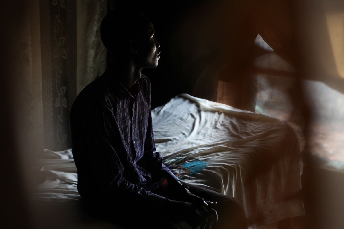 Y, 18, is posing for a photo in his home in the POC in Juba, where he has been living since January this year, on July 12th, 2018. He was going to school in Malakal when the war started. He fled to a
