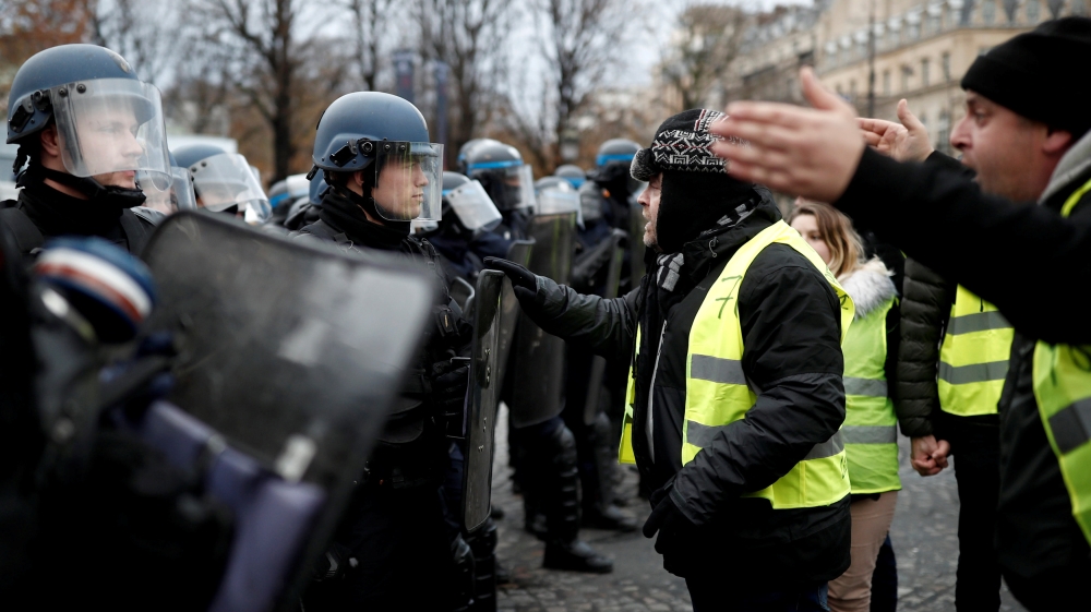 A protester wearing yellow vest, a symbol of a French drivers'' protest against higher fuel prices, talks to the police officer in Paris, France, November 24, 2019