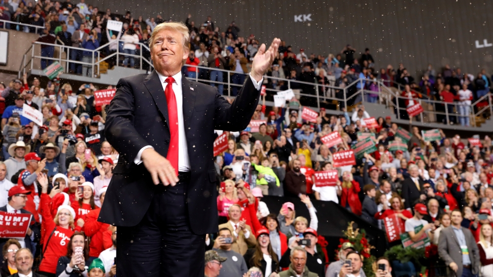 U.S. President Donald Trump gestures as artificial snow falls during his address to supporters at a Make America Great Again rally in Biloxi, Mississippi, U.S., November 26, 2018.