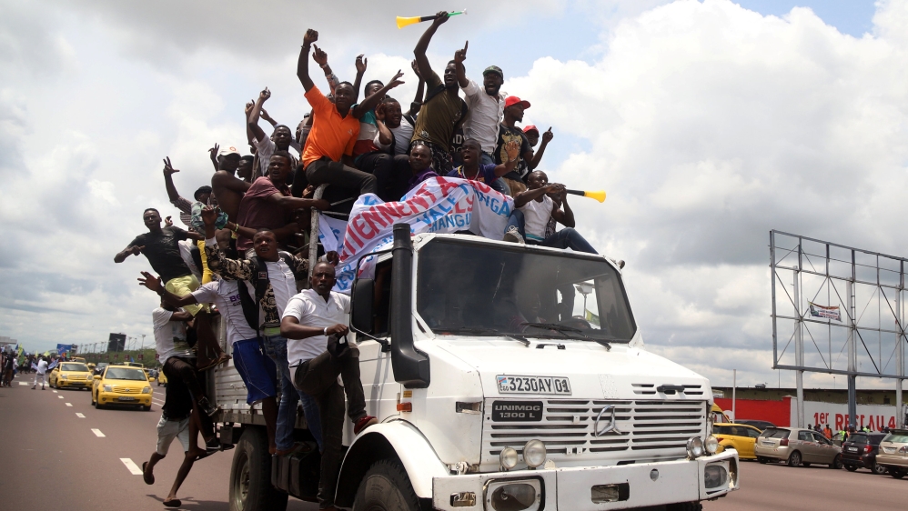 Supporters of Congolese opposition presidential candidate Martin Fayulu chant slogans while riding on a truck as they welcome him at N''djili International Airport in Kinshasa