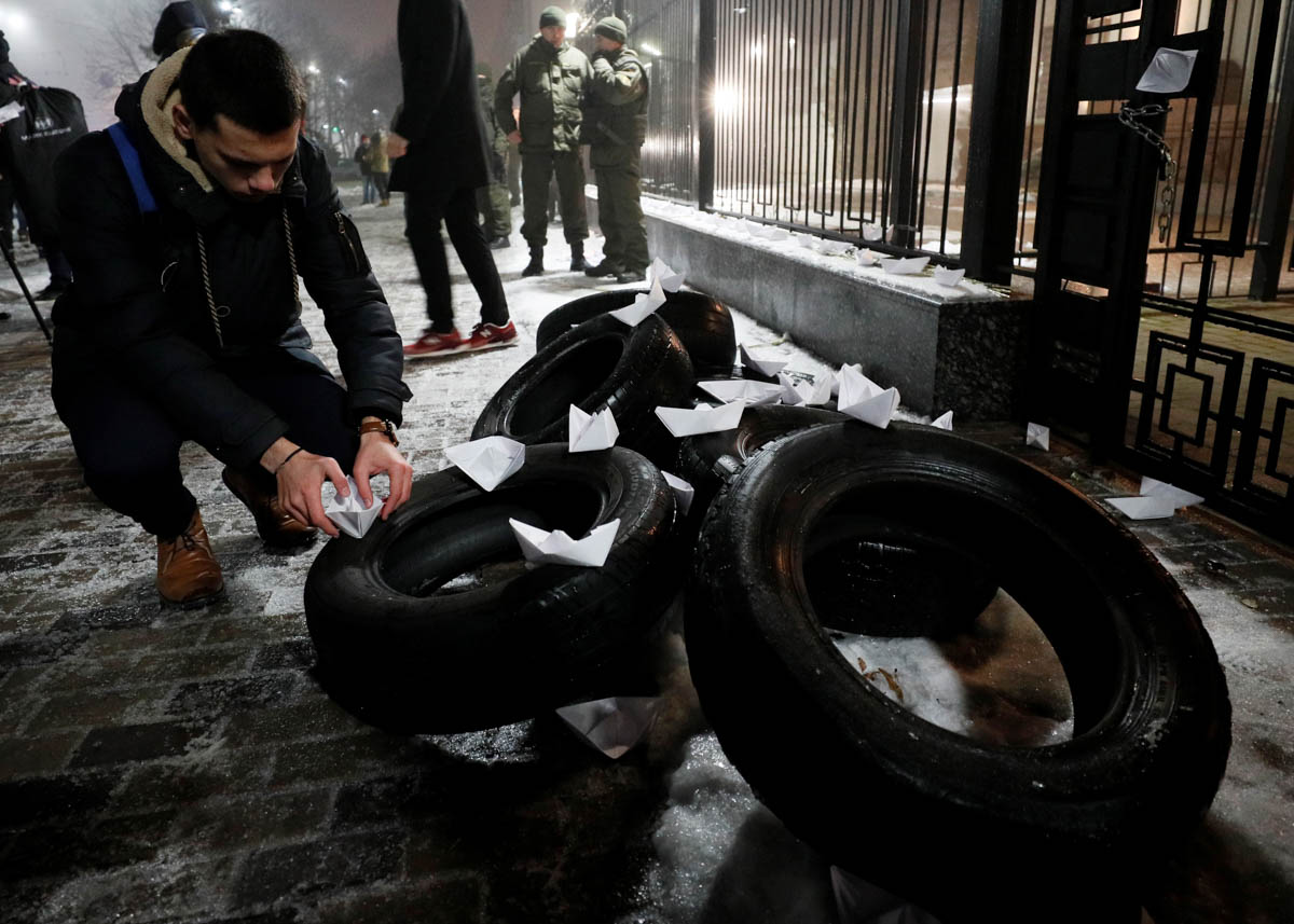 A man places a paper boat during a protest against the seizure