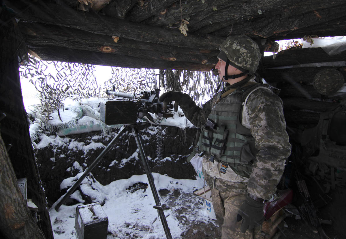 A Ukraine army soldier stands on duty with his heavy machine gun at an undisclosed location in eastern Ukraine, Monday, Nov. 26, 2018. Ukrainian lawmakers were set to consider a presidential request f