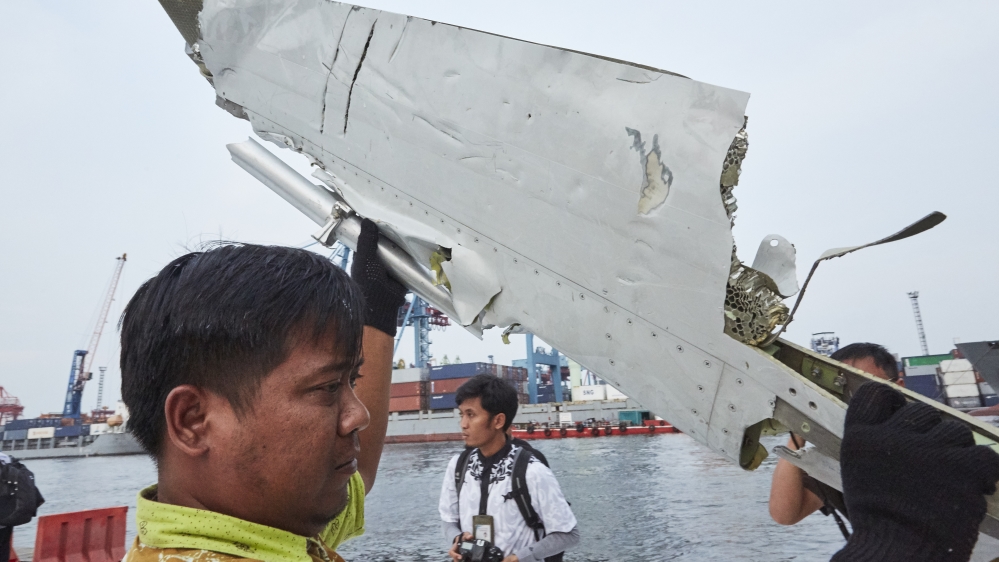 Man examines part of plane of Lion Air which crashed in 2018