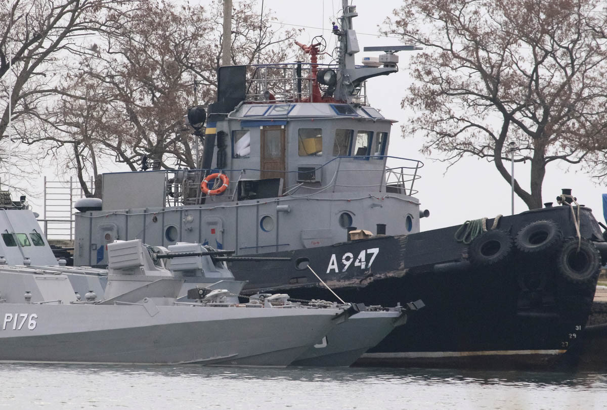 Seized Ukrainian ships, small armoured artillery ships and a tug boat, are seen anchored in a port of Kerch, Crimea November 26, 2018. REUTERS/Pavel Rebrov