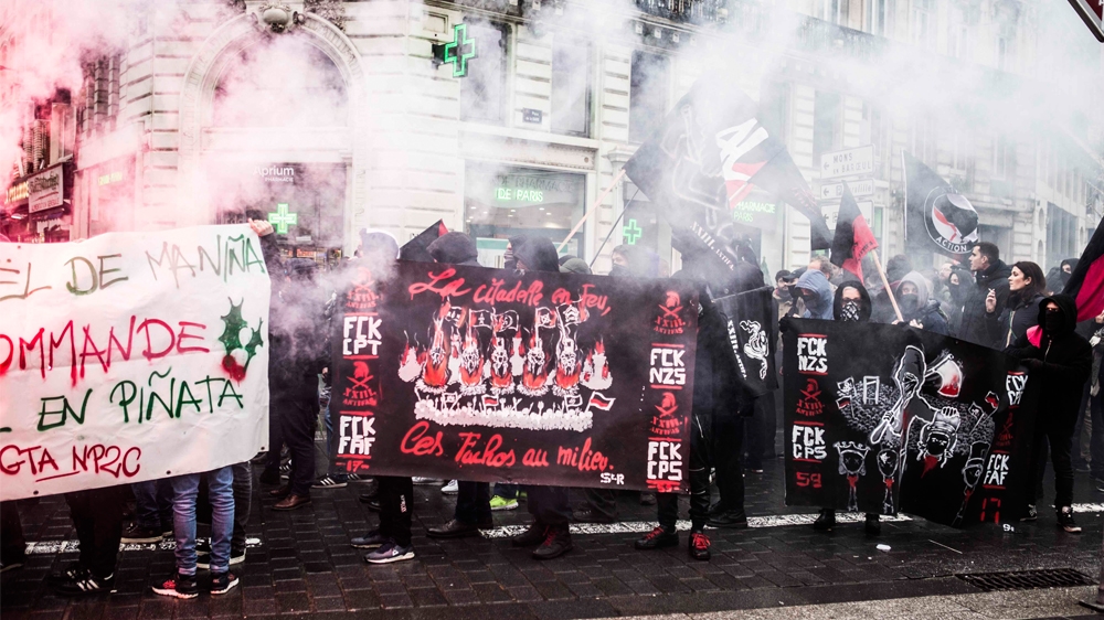 Activists protested against Generation Identity carrying banners that read 'The Citadel on fire, fascists in the midst' [Lucas Chedeville/Al Jazeera]