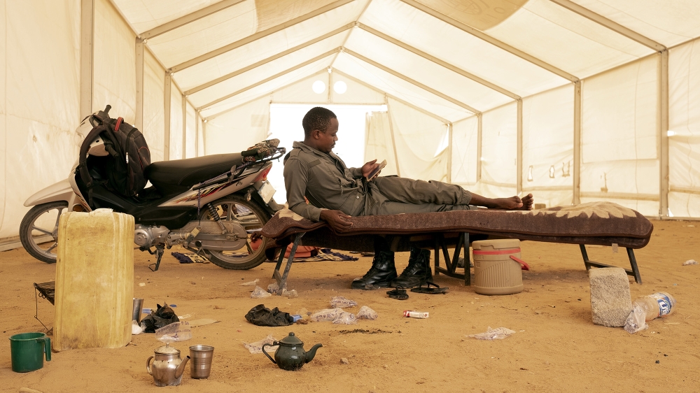 A Niger army soldier waiting for a convoy of migrants rejected by Algeria in the suburbs of Agadez, Niger, 2018 [File: Francesco Bellina/Al Jazeera]