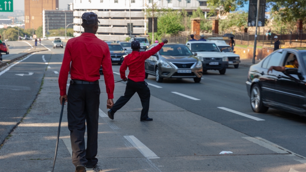 The safety wardens take an active role to keep the busy intersection crime-free [Tshego Mmahlatji/Al Jazeera]