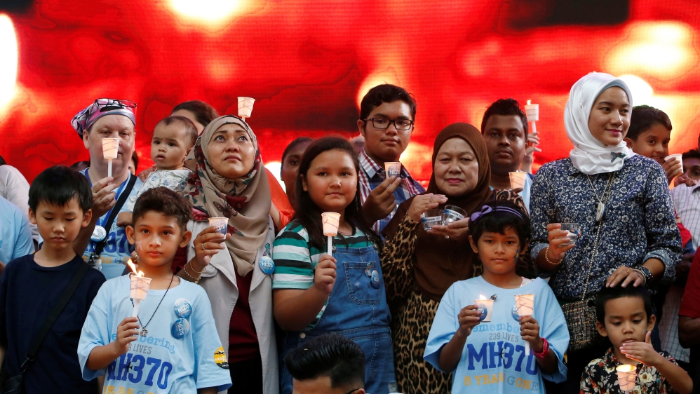 Family members hold candles during the fifth annual remembrance event for the missing Malaysia Airlines flight MH370, in Kuala Lumpur