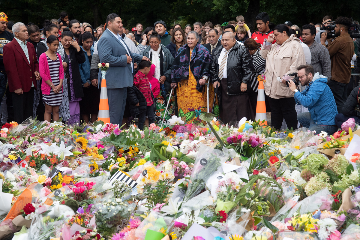 Samoan church members sing next to floral tributes in Christchurch on March 17, 2019, two days after a shooting incident at two mosques in the city.