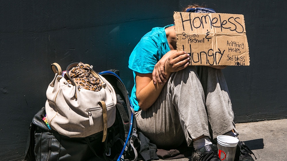 A homeless woman sits on the street in Las Vegas, Nevada [File: George Rose/Getty Images)