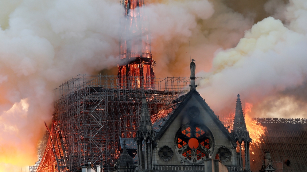 Smoke billows as fire engulfs the spire of Notre Dame Cathedral in Paris, France April 15, 2019. REUTERS/Benoit Tessier -