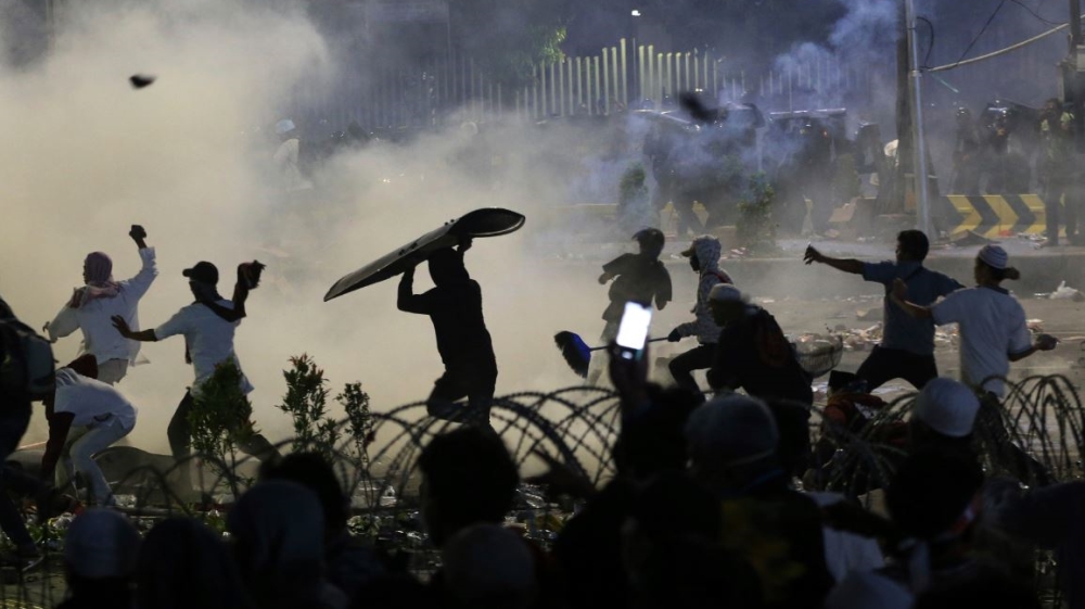 Protesters throw rocks and other objects towards police