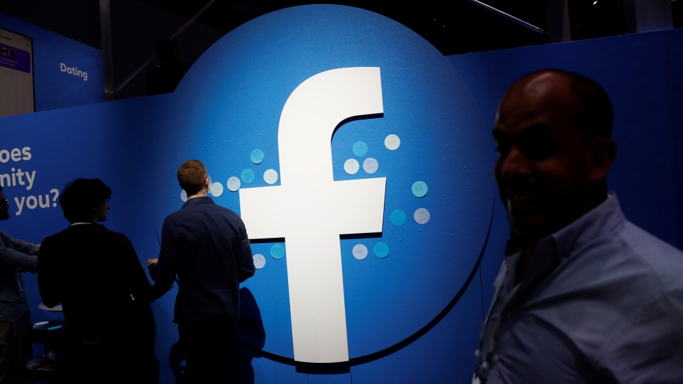 Attendees walk past a Facebook logo during Facebook Inc''s F8 developers conference in San Jose