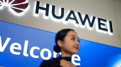 This file picture taken on May 15, 2019 shows a hostess welcoming journalists and guests to the Huawei database and storage product launch during a press conference at the Huawei Beijing Executive Bri