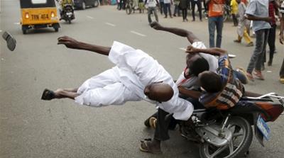 A pedestrian is hit by a motorcycle taxi during a political rally