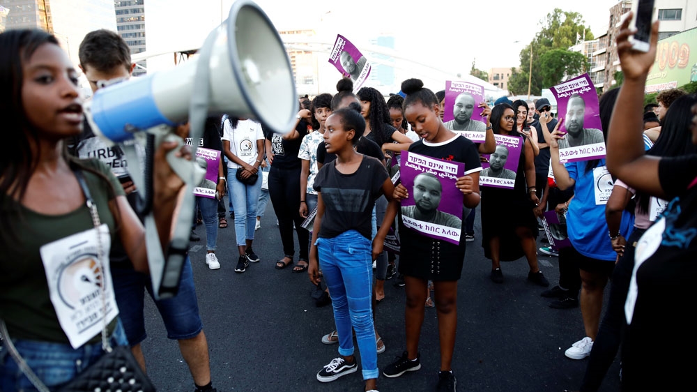 Protestors shout slogans as they block a main road during a protest for the death of 18-year old Solomon Tekah of Ethiopian descent