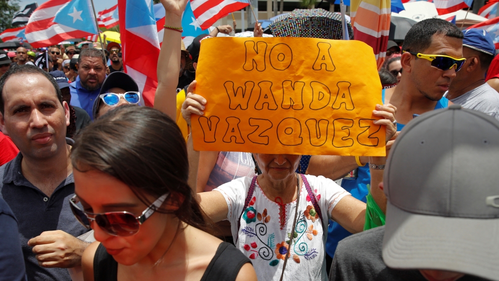 A woman holds a sign that reads “No to Wanda Vazquez” during a rally in San Juan, Puerto Rico