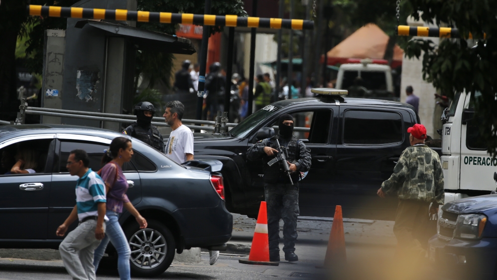 Masked agents of Venezuela’s police intelligence agency stand guard at the entrance of the opposition-controlled congress