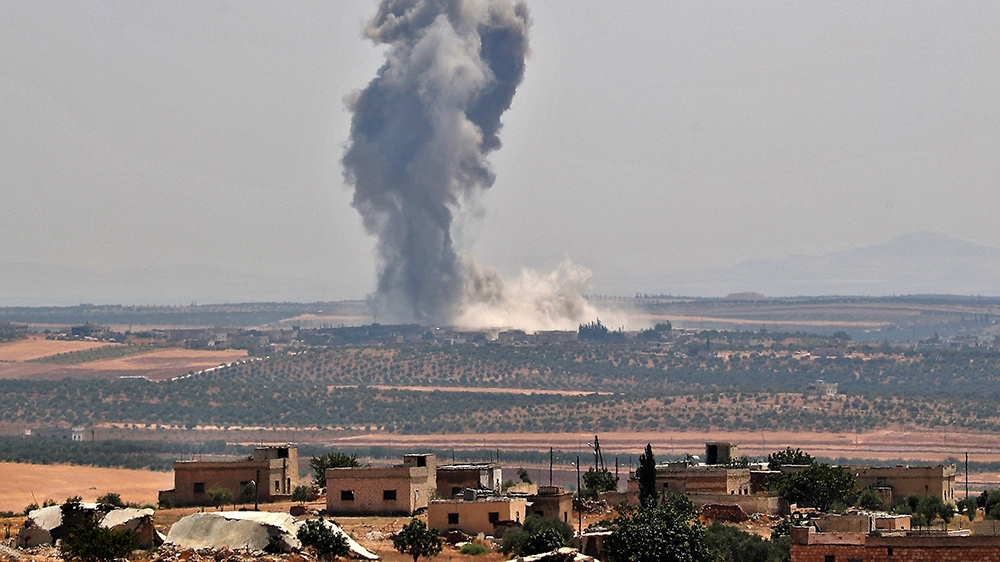Smoke billows above buildings during a reported air strike by pro-regime forces on Khan Sheikhun in Syria''s Idlib province on August 19, 2019. - A Turkish military convoy crossed into northwest Syria