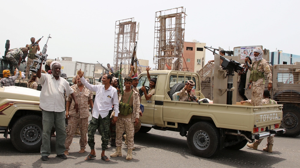 Members of UAE-backed southern Yemeni separatist forces shout slogans as they patrol a road during clashes with government forces in Aden