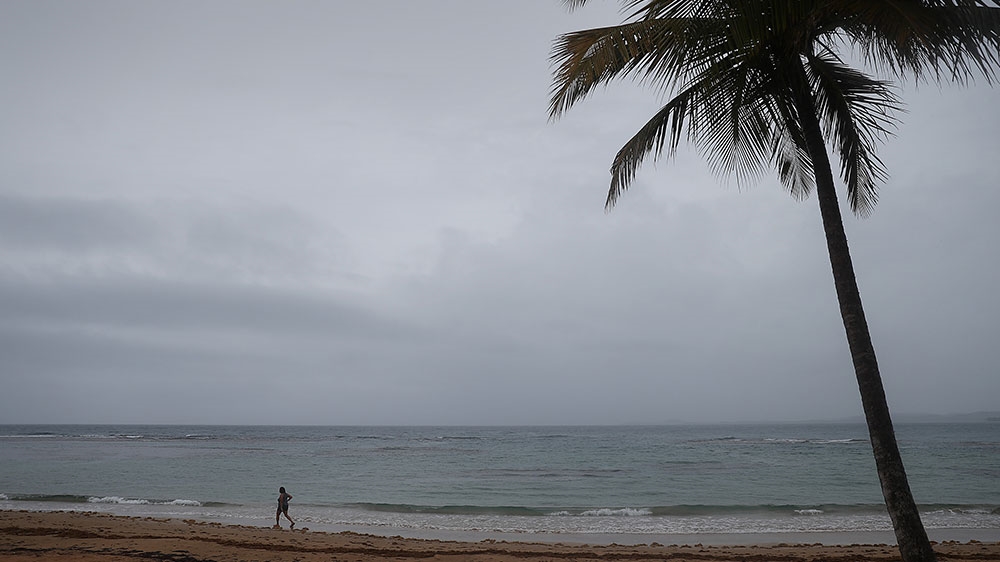 A person is seen along the beach as the storm passes the island on August 28, 2019, in Luquillo, Puerto Rico
