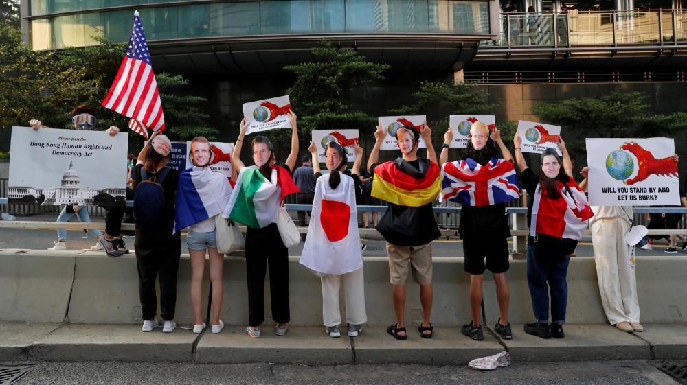 Protesters wear masks of the G7 leaders during the rally in front of the US consulate in Hong Kong [Reuters]