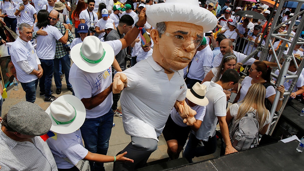 A supporter dressed as former Colombian President Alvaro Uribe goes on stage during a demonstration in support of the former president in Medellin, Colombia