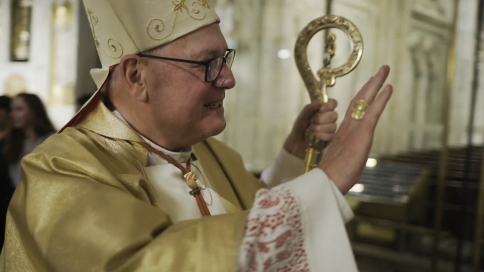 Cardinal Timothy Dolan greets visitors to Saint Patrick’s Cathedral in New York City in June. Fault Lines met him there to ask why a priest accused of abuse by several men had remained in active ministry for months – and in one case, years after a complaint had been made