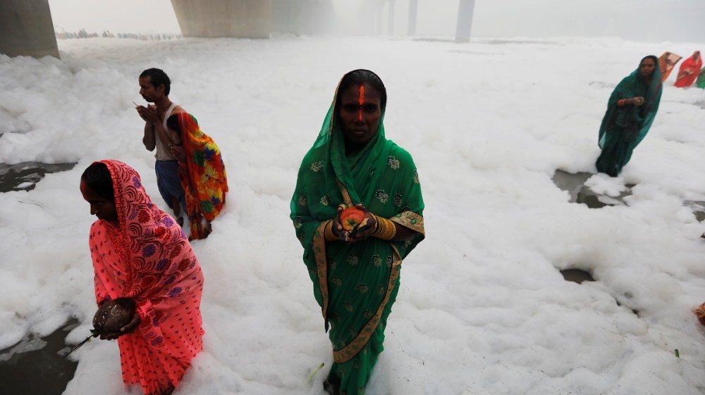 Hindu women worship the Sun god in the polluted waters of the river Yamuna during the Hindu religious festival of Chatth Puja in New Delhi, India, November 3, 2019. REUTERS/Adnan Abidi