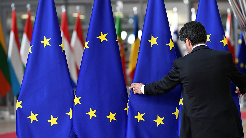 A staff member sets up EU flags ahead of a European Union leaders summit after European Parliament elections to discuss who should run the EU executive for the next five years, in Brussels,