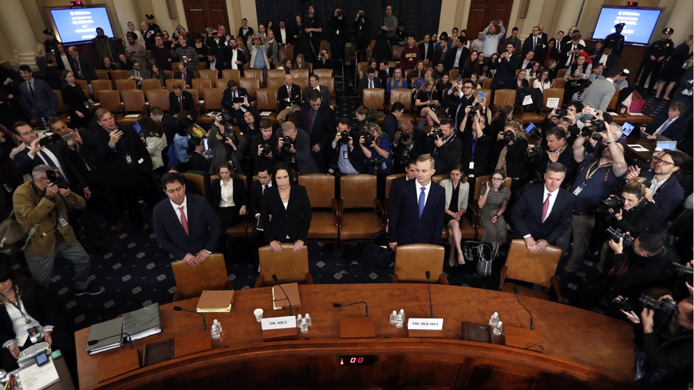 Former White House national security aide Fiona Hill, second from left, and David Holmes, a US diplomat in Ukraine, stand behind their chairs as they arrive to testify