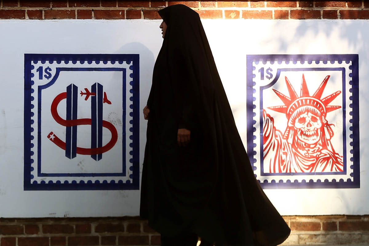 A woman walks past an Anti US mural on the former US embassy''s wall in Tehran, Iran. [Nazanin Tabatabaee/West Asia News Agency/Reuters]
