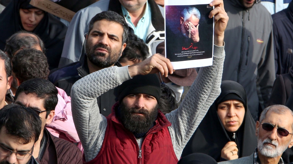 A man holds a picture of slain Iranian Revolutionary Guard Major-General Qassem Soleimani during a demonstration in Tehran