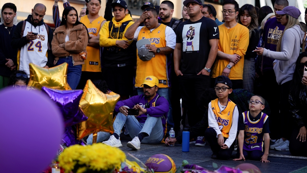 Fans of NBA basketball star Kobe Bryant pay their respects at a memorial outside the Staples Center at LA Live in Los Angeles on Monday