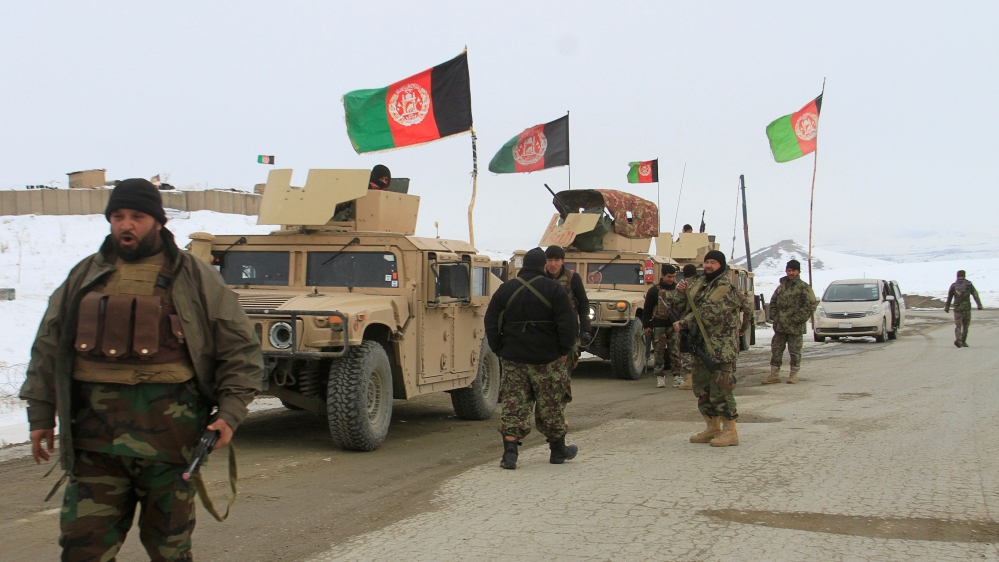 Afghan National Army forces go towards the site of an airplane crash in Deh Yak district of Ghazni province