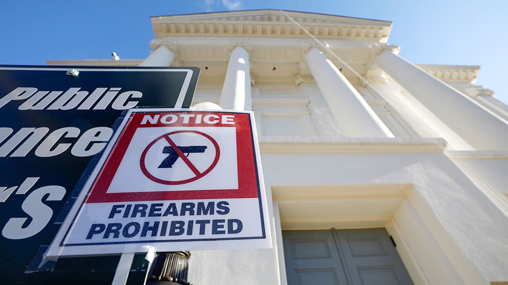 A sign warns visitors not to enter the Virginia State Capitol building with their firearms as security ramps up before a Monday rally by gun rights advocates and militia members in Richmond, Virginia