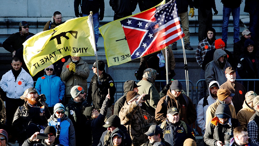 Gun rights advocates fly flags, including a composite of the Confederate and US flag, at a rally around Virginia’s Capitol, in Richmond, Virginia