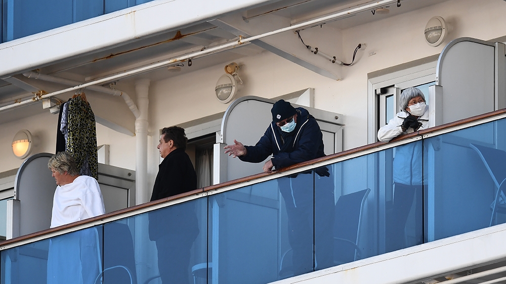 Passengers stand on balconies on the Diamond Princess cruise ship, with around 3,600 people quarantined onboard due to fears of the new coronavirus, at the Daikoku Pier Cruise Terminal in Yokohama por