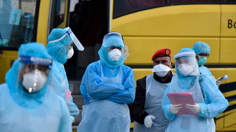This handout photo taken and released by Malaysia''s Ministry of Health shows health officials in protective suits at the Kuala Lumpur International Airport in Sepang, Malaysia, Tuesday, Feb. 4, 2020,