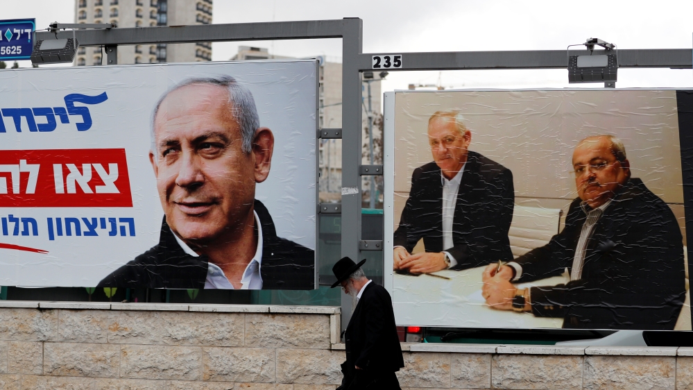 An ultra-Orthodox Jewish man walks next to Likud party election campaign banners in Jerusalem