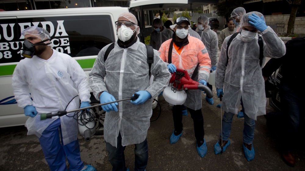 Palestinians workers in a protective suits get ready to disinfect mosques and churches as a preventive measure against the coronavirus in the West Bank city of Ramallah, Saturday, March 7, 2020.(AP Ph