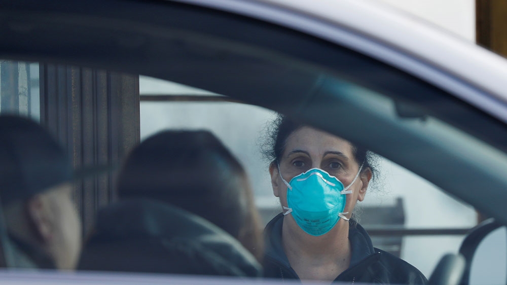 A healthcare worker assisting people arriving at the checkpoint of a testing facility for coronavirus disease in Jones Beach on Long Island in New York, US