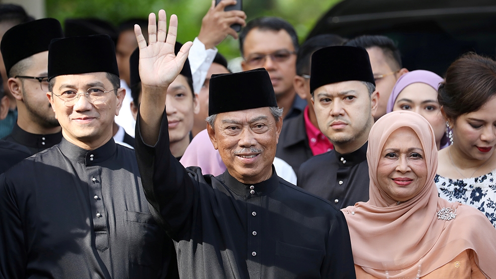 Malaysia's Prime Minister Designate and former interior minister Muhyiddin Yassin waves to reporters before his inauguration as the 8th prime minister, outside his residence in Kuala Lumpur, Malaysia,
