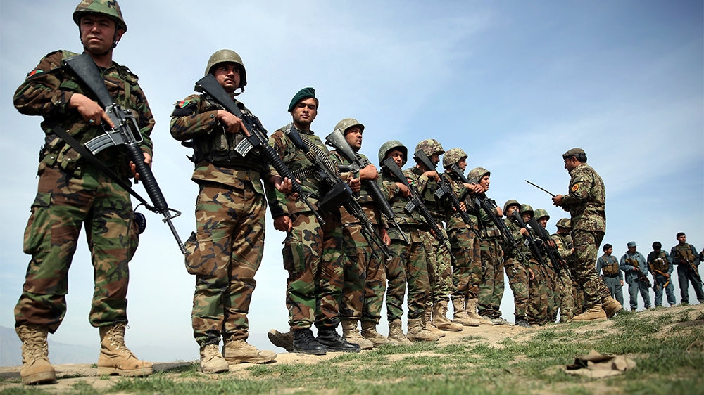 FILE - In this Tuesday, March 15, 2016 file photo, Afghan National Army soldiers stand guard, following weeks of heavy clashes to recapture the area from Taliban militants in Dand-e Ghouri district in