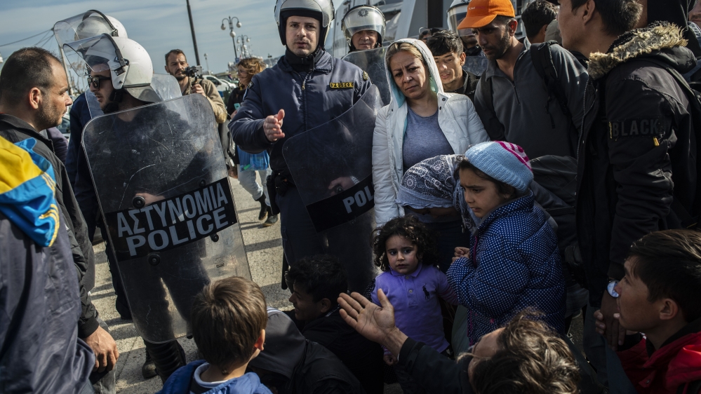 Riots police push back migrants outside the port of Lesbos