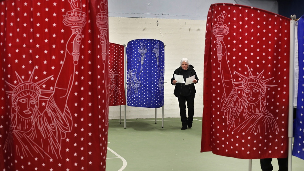 Louise Wilcox checks her ballots after coming out of a booth while voting in the primary election in Maine
