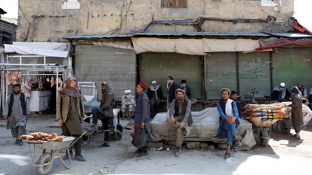 Afghan workers sit as most shops in Kabul are closed due to the coronavirus outbreak
