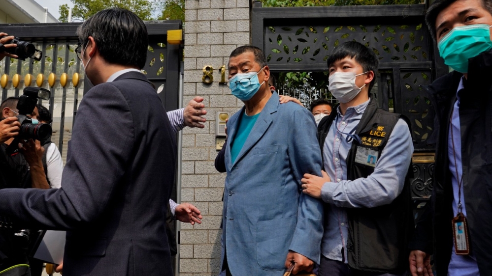 Hong Kong media tycoon Jimmy Lai, centre, who founded local newspaper, Apple Daily, was arrested by police officers at his home in Hong Kong on April 18